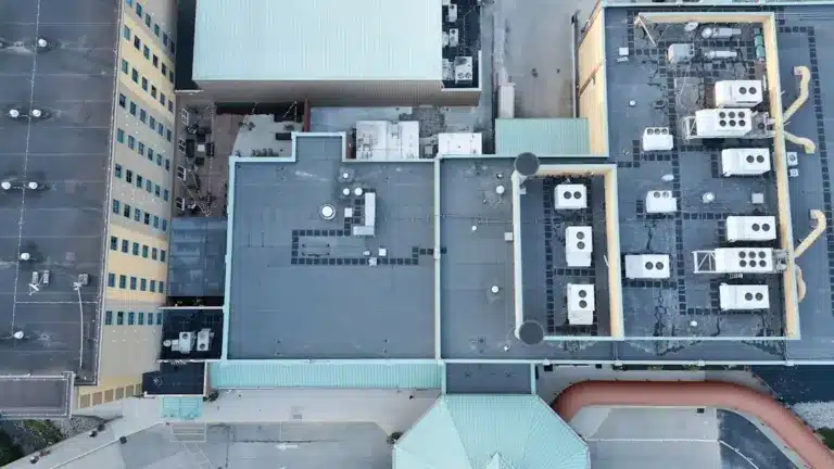 Aerial view of commercial building rooftop with multiple HVAC units and mechanical equipment installations.