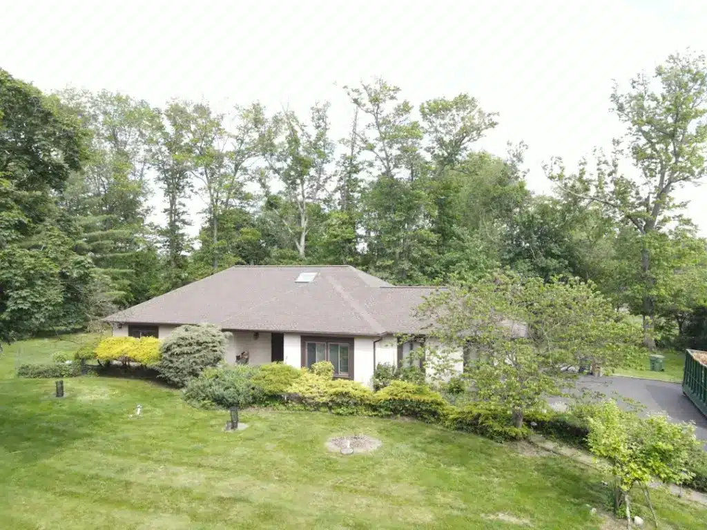 Single-story residential home with newly installed dark gray asphalt shingle roof and manicured landscaping.